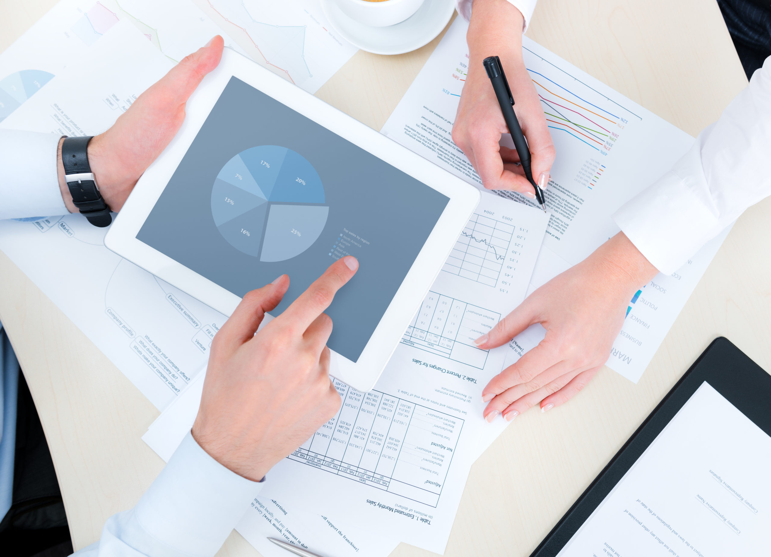 Business people developing a business project and analyzing market data information on a modern digital tablet computer. Top view photoshoot.